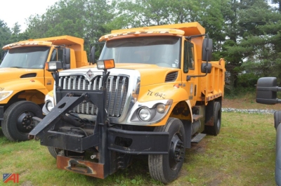 Two yellow International Workstar 7300 dump trucks parked side by side in a lot.