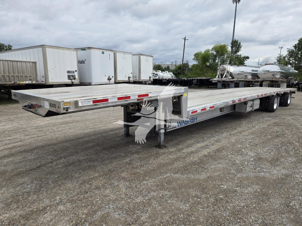 Wabash aluminum drop deck trailer showing long flatbed with rear ramps and dual rear axles.