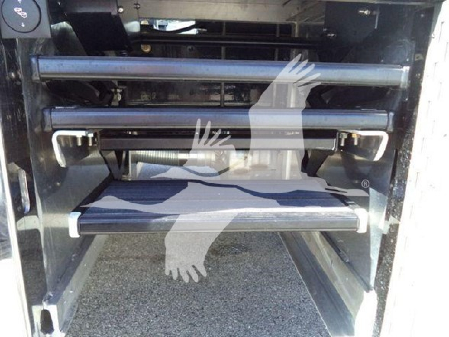 Kenworth T280 rollback truck image showing front bumper steps and storage area with metal bars and hydraulic components.