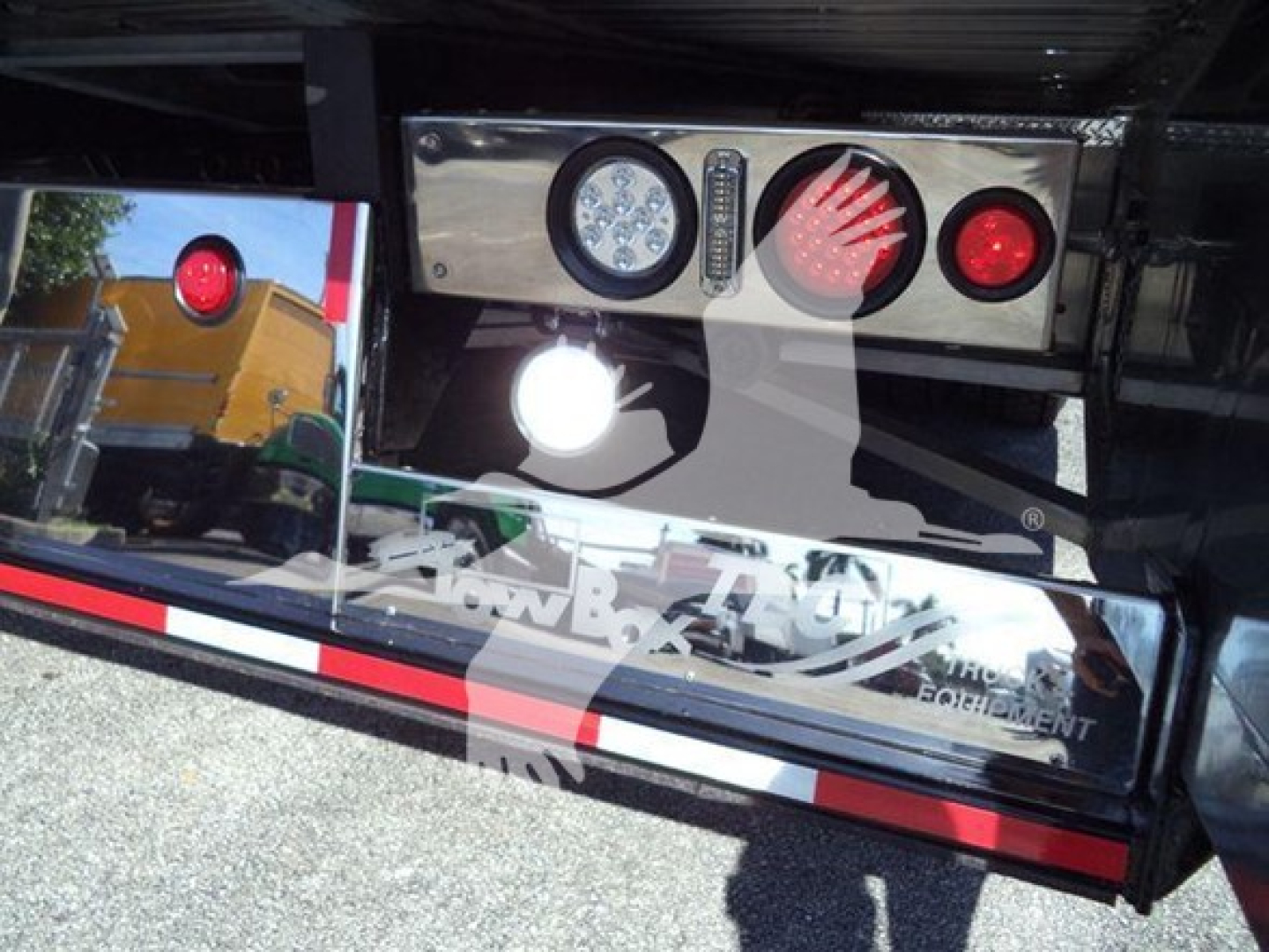 Kenworth T280 rollback truck rear bumper with chrome panel and lights. Visible are circular taillights, reverse light, and chrome lettering on bumper, reflections in polished surface.