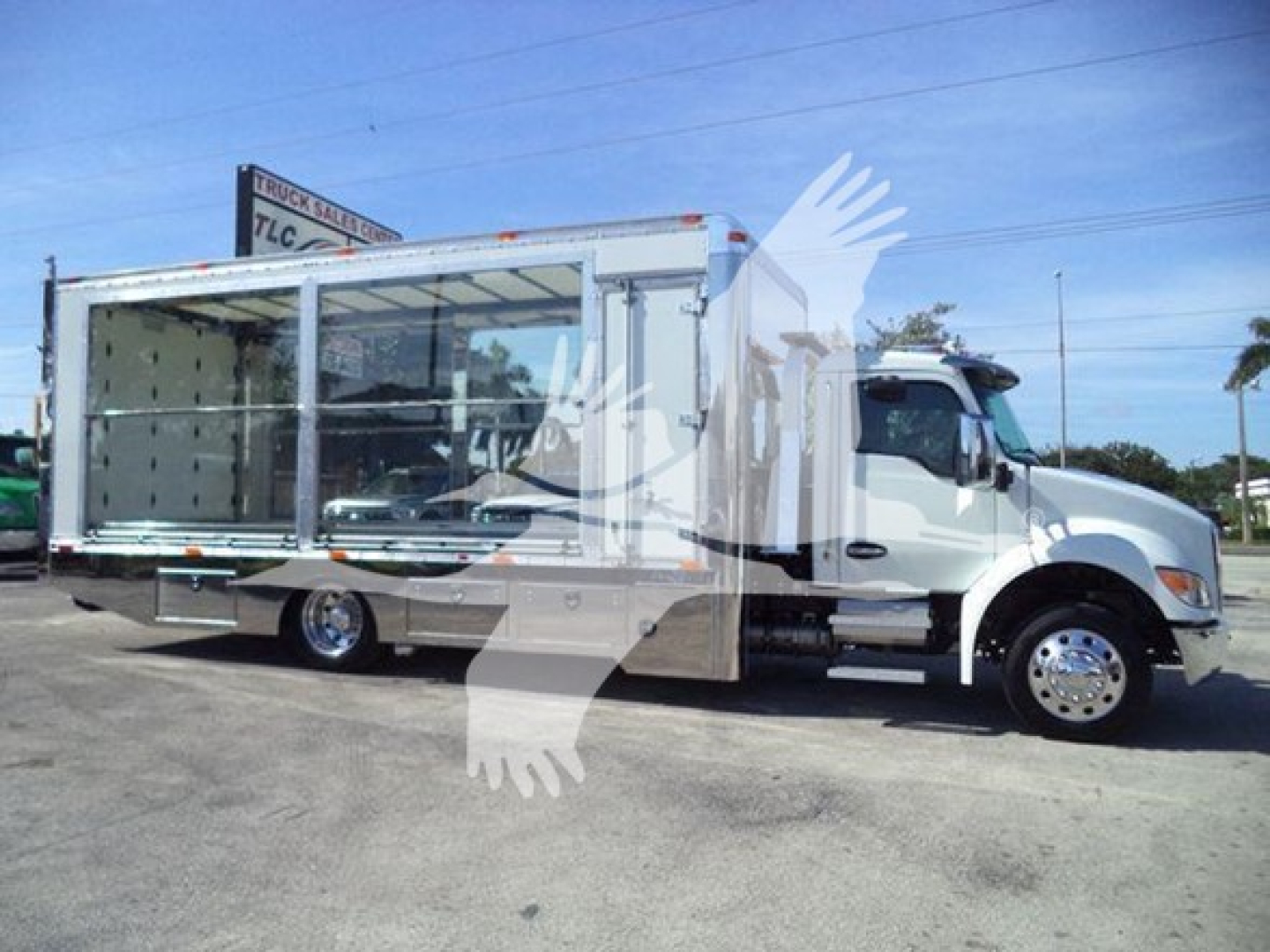 Kenworth T280 rollback truck with open cargo area and large chrome wheels, side view showing cab and empty cargo compartment.