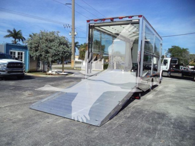 Kenworth T280 rollback truck with a large aluminum tilt ramp and rear loading platform, chrome metal finish, enclosed cab with glass panels, parking lot background.