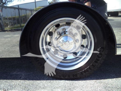 Kenworth T280 rollback truck wheel close-up showing polished steel wheel and tire with wheel cover reflection.