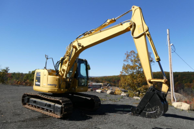 Komatsu PC128US-8 excavator in profile view showing hydraulic arm and bucket on tracked undercarriage.