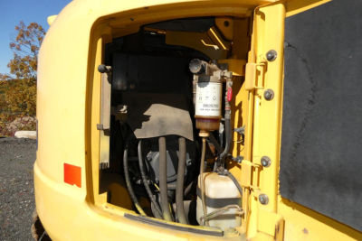 Komatsu PC128US-8 excavator hydraulic reservoir area with filter and hoses visible in open engine bay