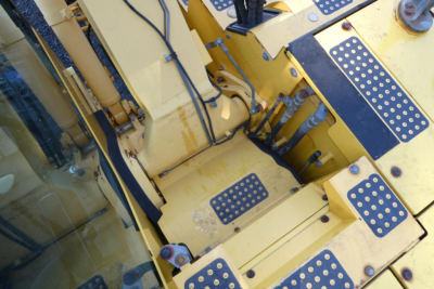 Komatsu PC128US-8 excavator interior platform with yellow steps and control area showing metal plates and hoses.