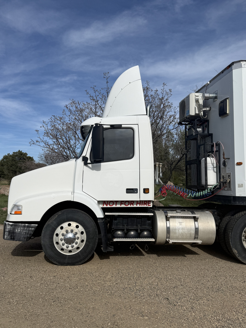 Volvo VNL64T300 truck cab and attached refrigeration unit, side view