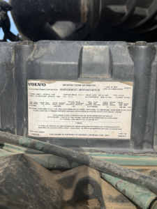 Volvo engine compartment label with warning and engine information plate visible on the engine bay.