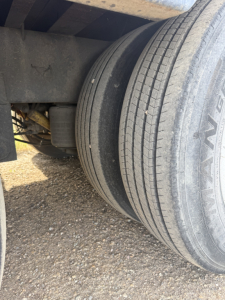 Volvo truck wheel area showing dual rear tires with tread and a portion of the axle housing. Visible markings on the tire read 'HAVAN' or similar partial. No other legible text.