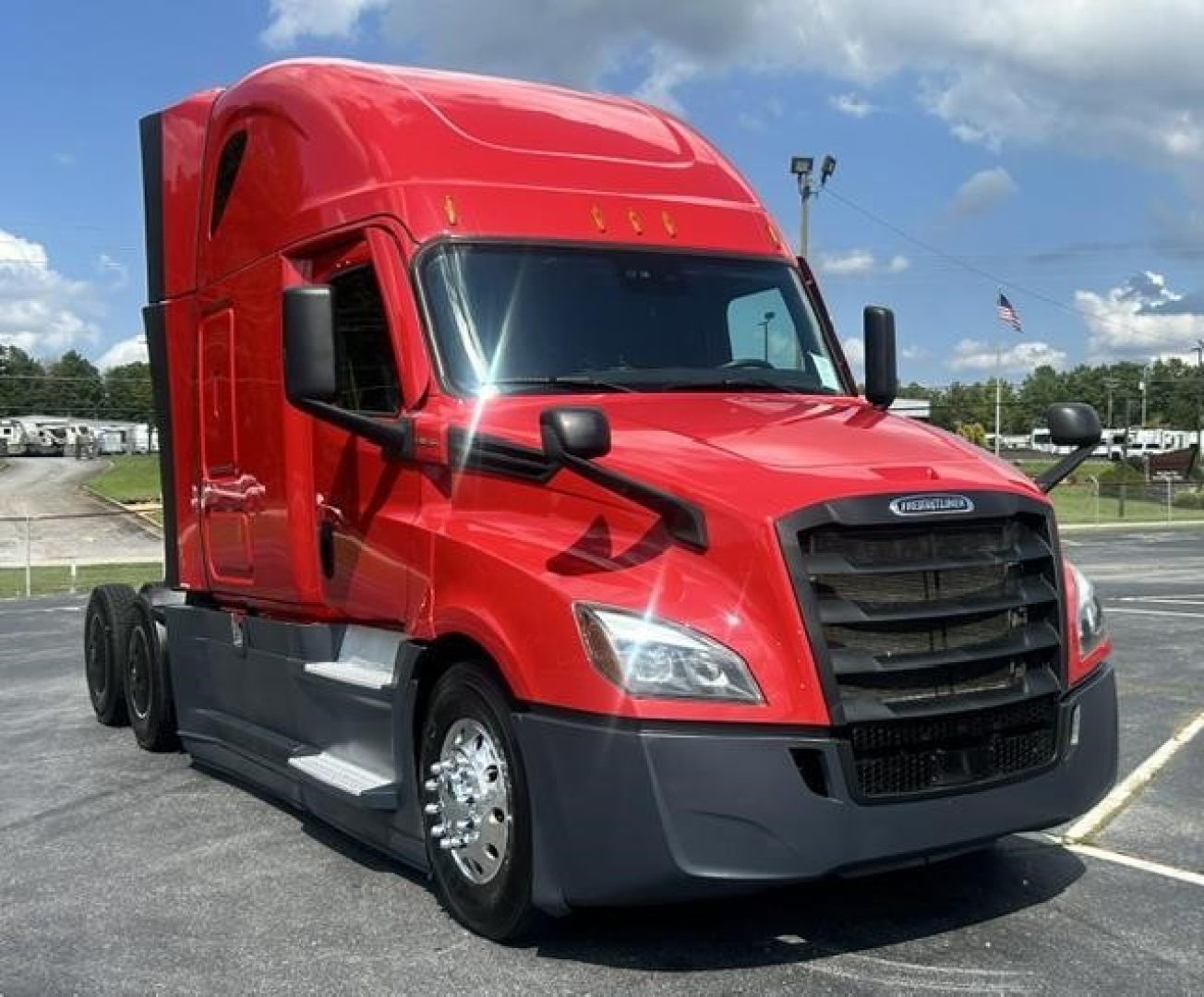 Freightliner Cascadia 126 sleeper truck in red, front-left view showing cab and grille, with black bumper and chrome wheels.