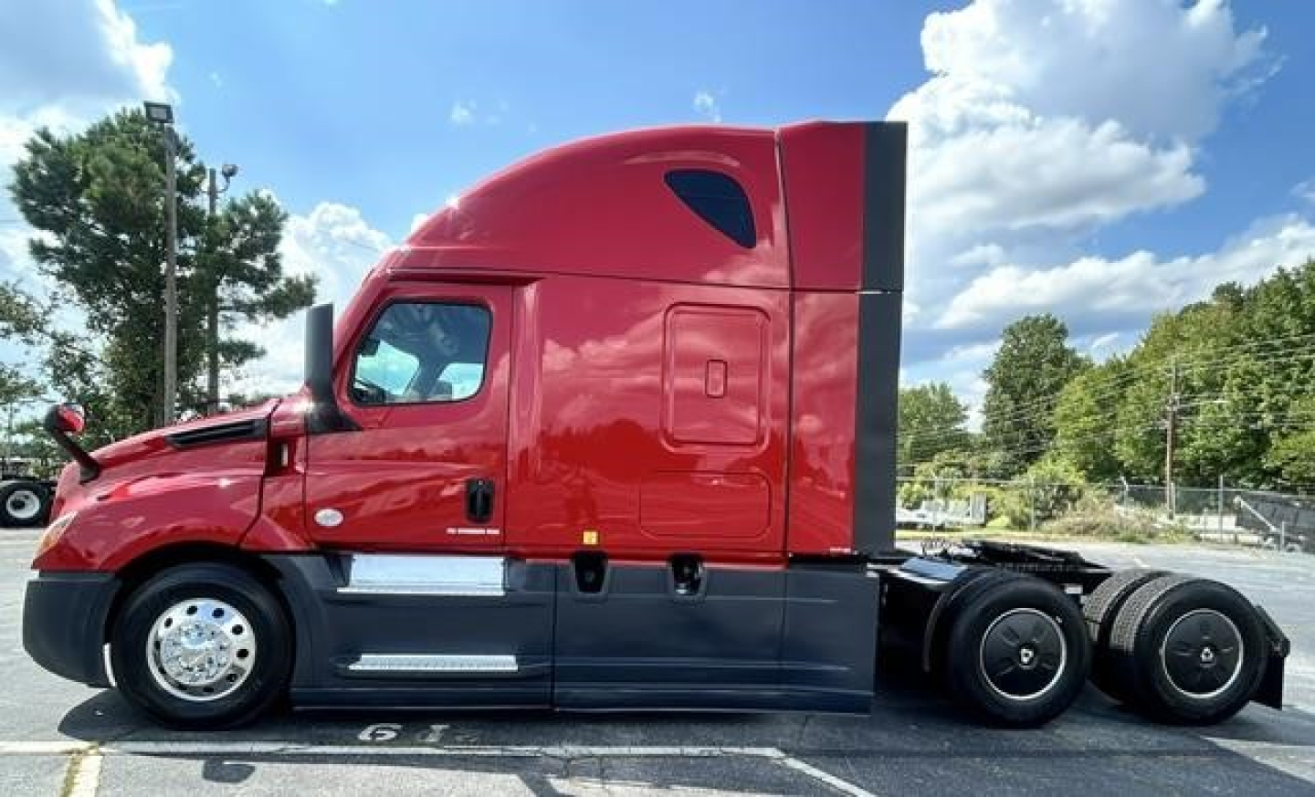 Freightliner Cascadia 126 conventional sleeper tractor side view showing red tractor cab and black lower body
