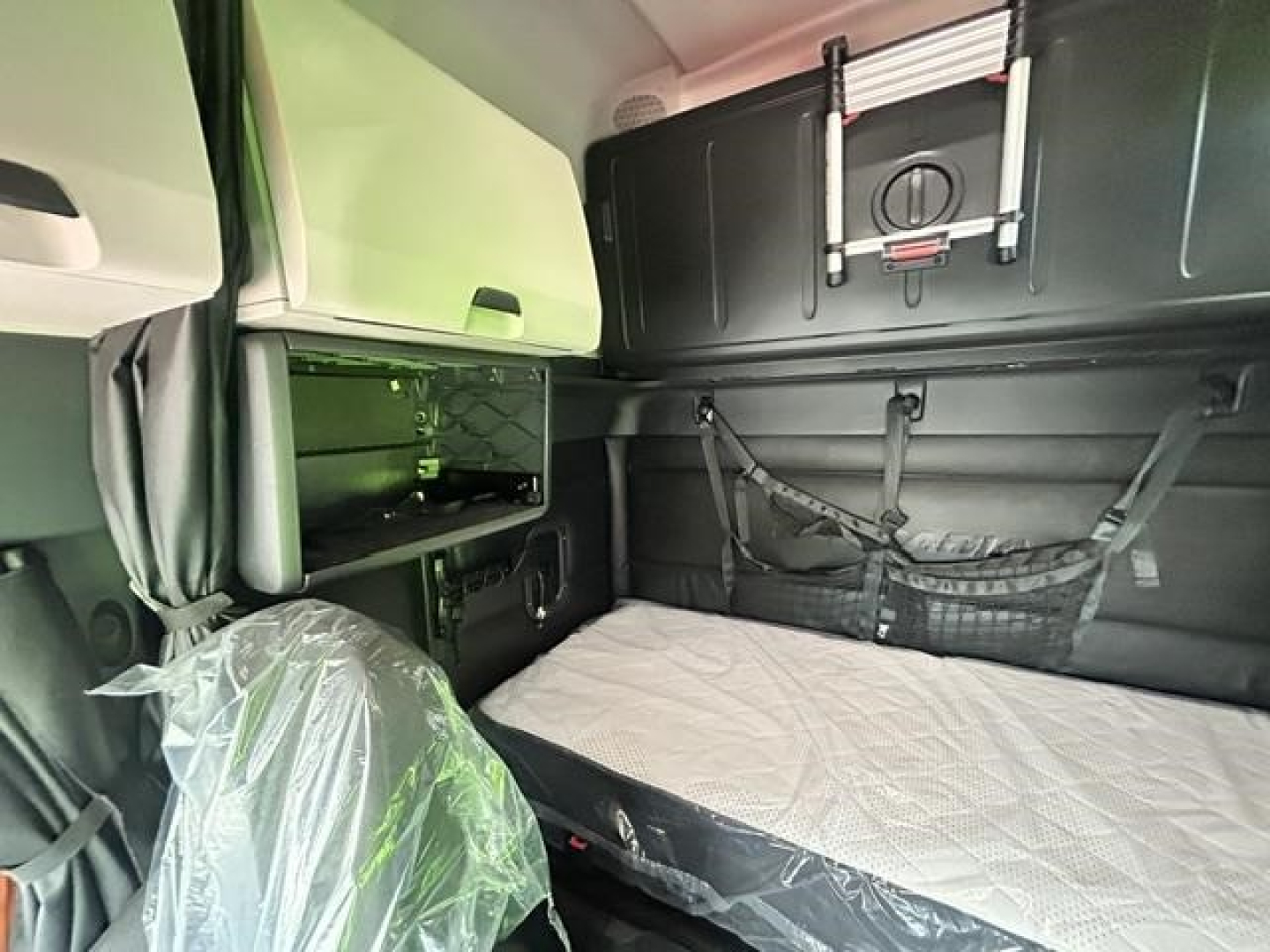 Truck sleeper cab interior showing storage compartments and bed in a 2023 Freightliner Cascadia 126.