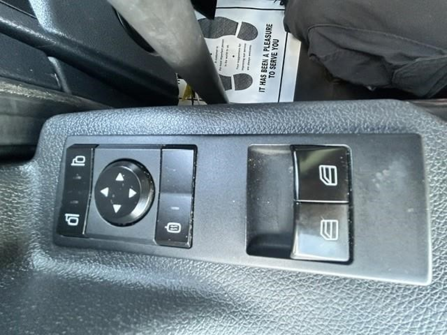 Freightliner Cascadia driver-side door control panel with mirror adjust and window switches visible