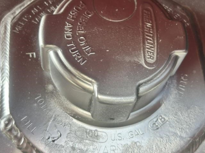 Cap near diesel exhaust fluid tank cap on Freightliner Cascadia 126 showing fuel cap text and warning inscriptions.