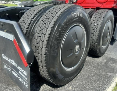 Dual rear BFGoodrich tires on a Freightliner Cascadia truck, wheel rims, with mudguard and fender visible; truck is in a parking lot.