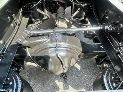 Rear view under Freightliner Cascadia showing driveshaft, differential housing, and suspension components.