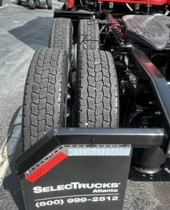 Freightliner Cascadia dual rear tractor tires showing wheel chassis andAdjacent side with SelectTrucks Atlanta branding plate and contact number