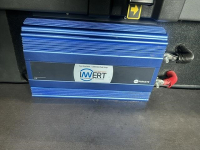 Blue Invert Pure Sine Wave inverter mounted in Freightliner Cascadia sleeper truck with red and black cables connected.