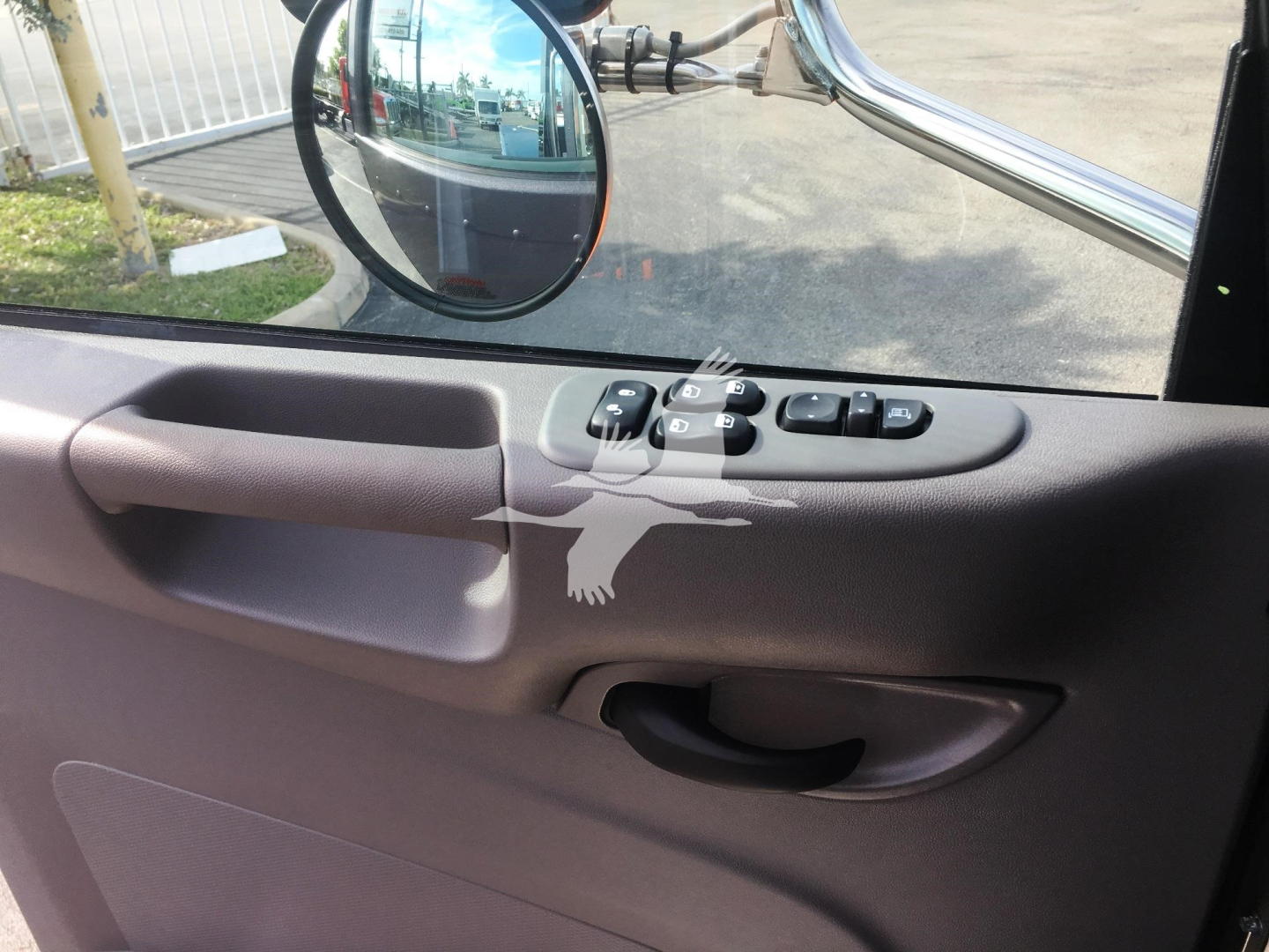 Truck interior door panel and mirror seen through window; control buttons on armrest; side-view mirror; source shows vehicle used in a listing.