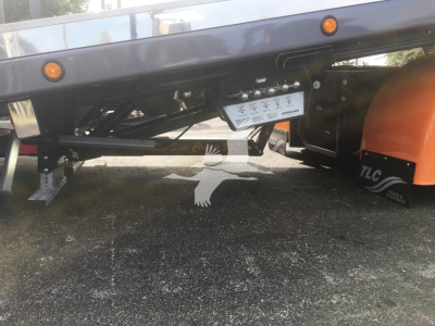 Peterbilt 337 rollback truck chassis showing undercarriage and control panel with warning labels.