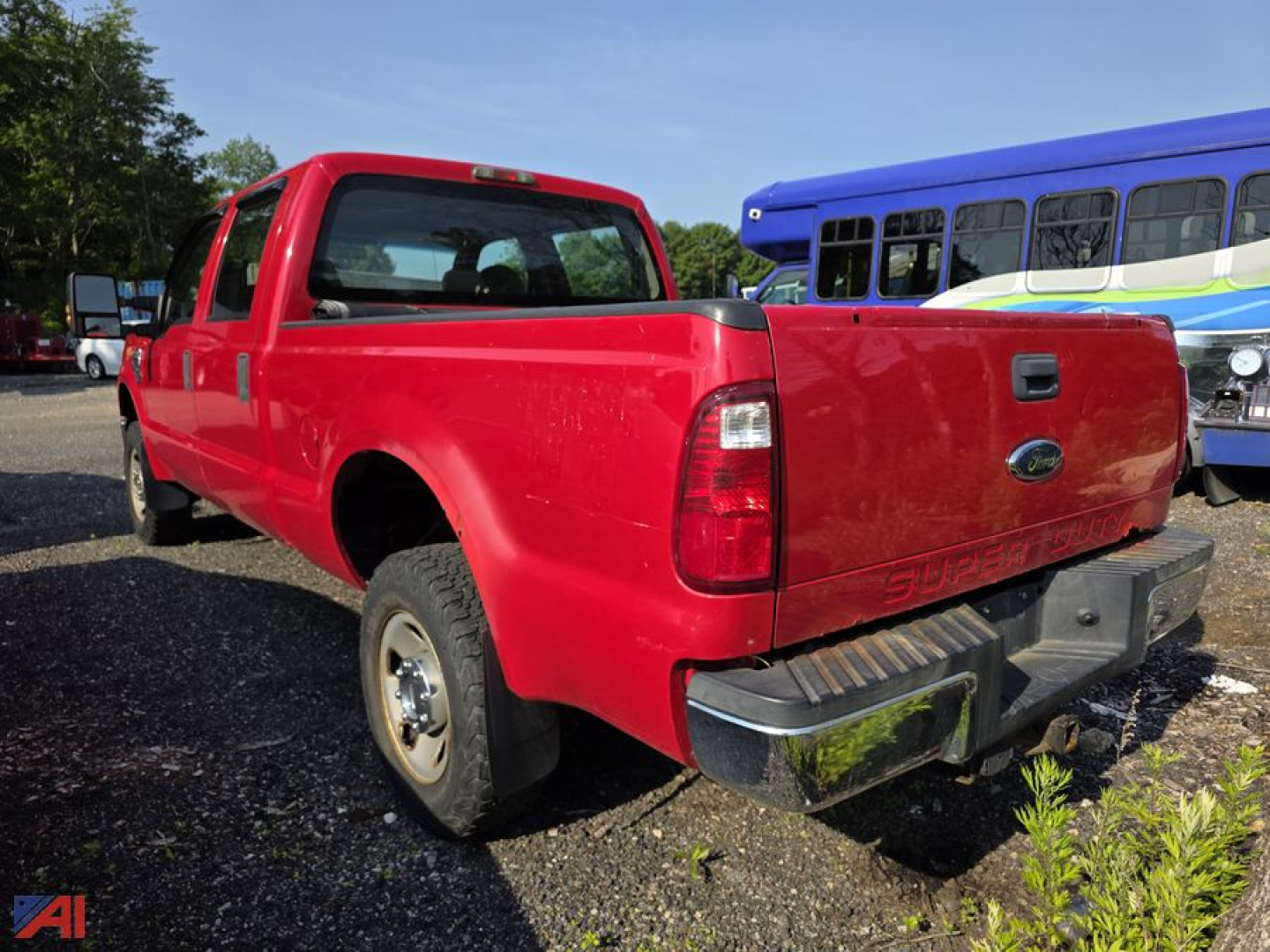 Ford F-250 Super Duty pickup truck rear/side view with red paint and crew cab, short bed, in a used lot.