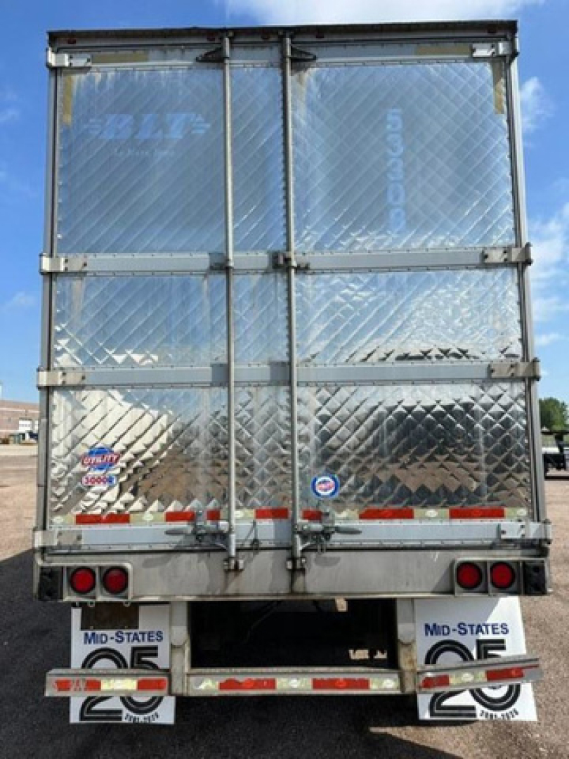 Rear view of a 2016 utility refrigerated trailer with diamond plate aluminum doors and dual rear doors, mid-states mud flaps, and reflective red/white tape.
