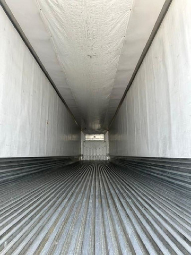 Trailer interior showing corrugated metal floor and white sidewalls, long narrow cargo area viewed from rear opening