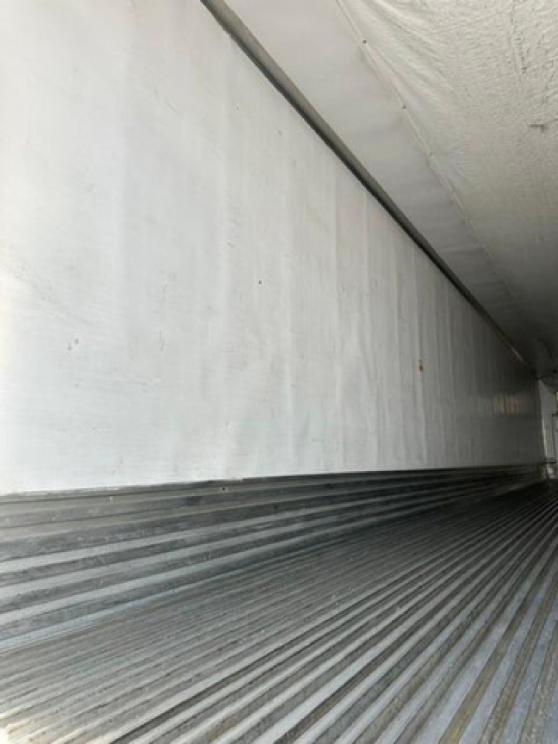 Trailer interior showing ribbed aluminum floor and smooth wall panels inside a refrigerated trailer.