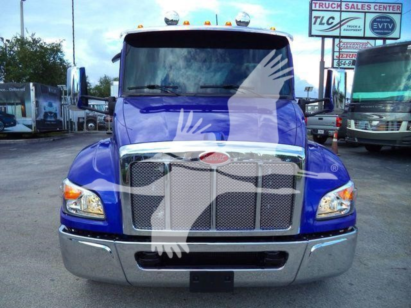 Front view of a blue 2025 Peterbilt 536 rollback truck with chrome grille and bumper, showing bumper, headlights, and Peterbilt emblem.