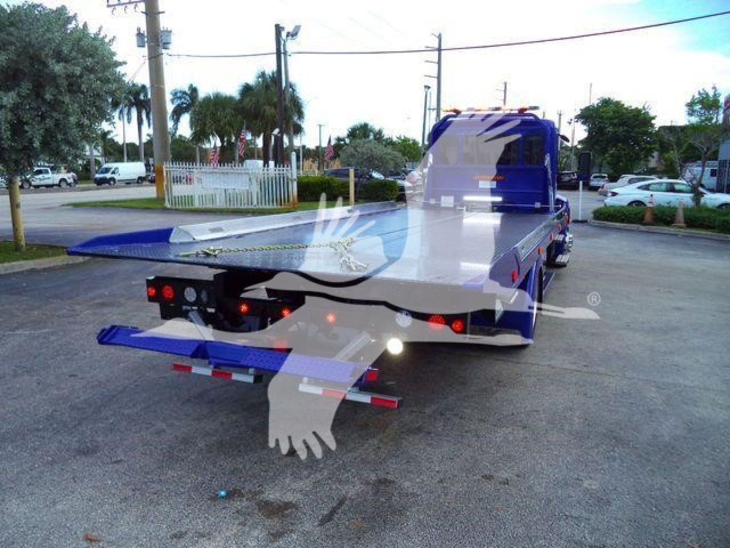 Peterbilt 536 rollback truck rear/side view showing blue flatbed with wheel lift and rear lights.