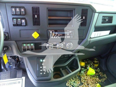 Truck cab interior showing dashboard controls and gear selector.