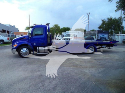 Blue Peterbilt 536 rollback truck side view showing cab and long flatbed with chrome wheels.