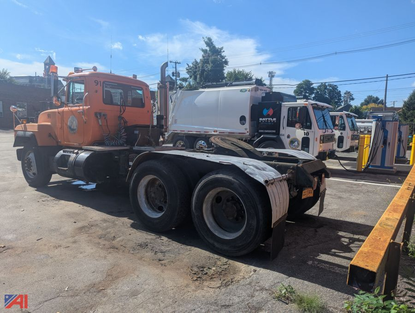 Mack RD6 tractor in service showing dual rear axles and orange cab with black chassis.
