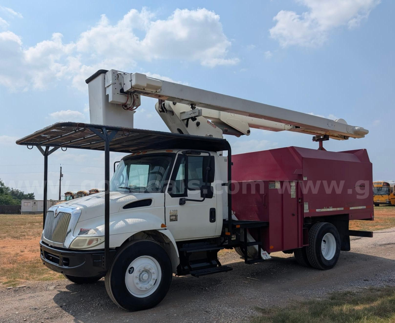 Truck mounted boom lift on a white International DT466 diesel bucket truck showing hydraulic boom and pink utility bed.