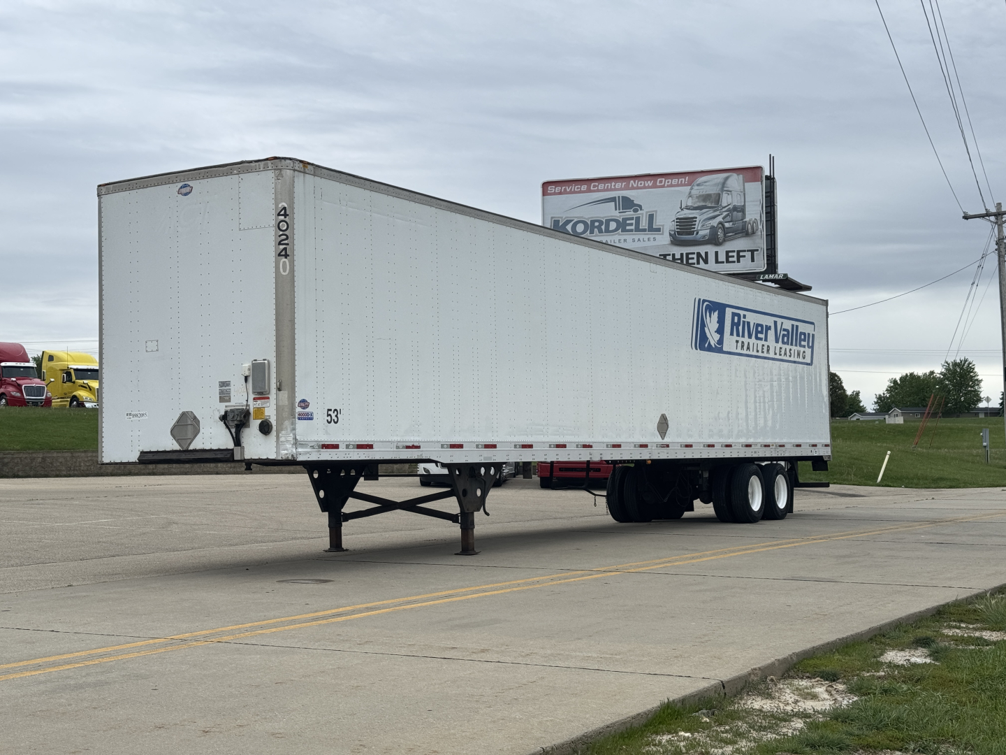 Utility 4000Dx trailer in a parking lot showing raised riveted aluminum siding, dual rear axles, and a River Valley trailer logo on the side.