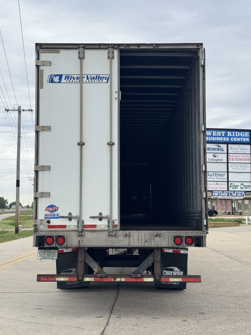 Trailer rear view showing empty cargo space inside a white River Valley refrigerated trailer with open doors and taillights visible.