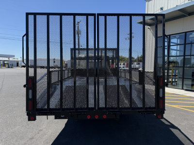 Isuzu NQR flatbed truck rear view with metal mesh gate and tail lights.