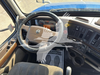 Volvo VNL cabin interior showing steering wheel, dashboard gauges, and center console with multiple control panels.