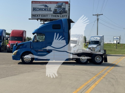 2017 Volvo VNL64T670 conventional sleeper truck in blue, side view, parked at a dealership lot with other trucks; visible sign reads Kordell and Next Exit.