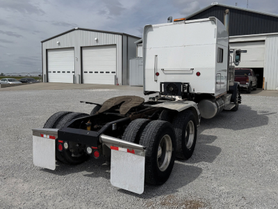 Peterbilt 389 UltraCab tractor rear view showing fifth-wheel, dual rear axles, and mud flaps.