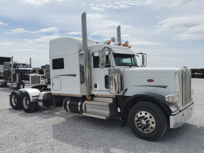 Peterbilt 389 UltraCab tractor truck side view with chrome exhaust stacks and large front grille.