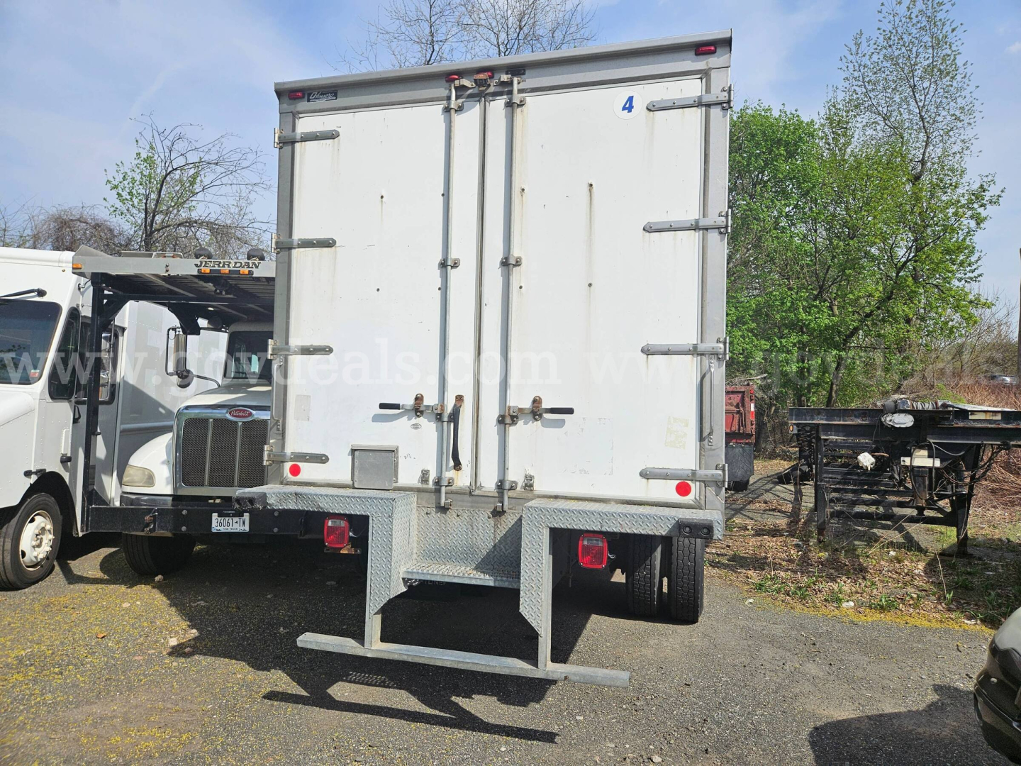 Rear view of a 2020 Freightliner M2 106 box truck showing cargo doors, rear bumper step, and dual rear lights.