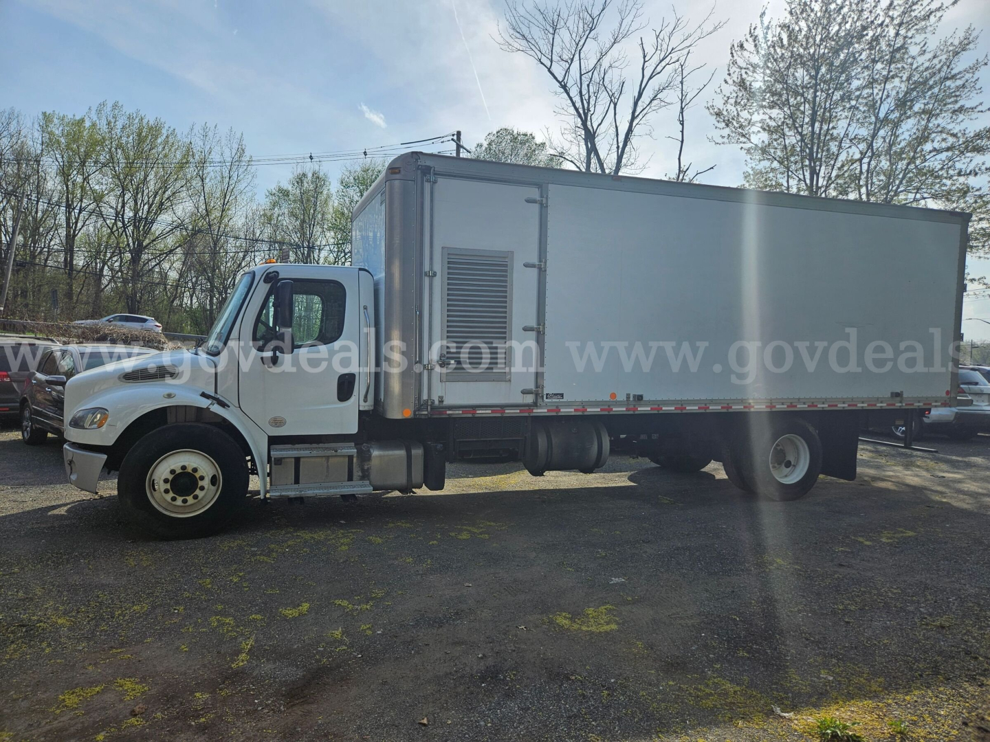 Truck side view showing a 2020 Freightliner M2 106 box truck with a gray cargo box and white cab, VIN 1FVACWD30LHLR3706, stock 32136-5, utility truck.