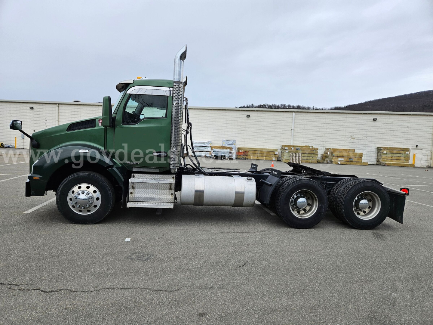 Side view of a green 2017 Kenworth T880 heavy truck tractor chassis with dual rear axles and fuel tanks, VIN 1XKZDK8X5HJ148843, stock 32136-26.