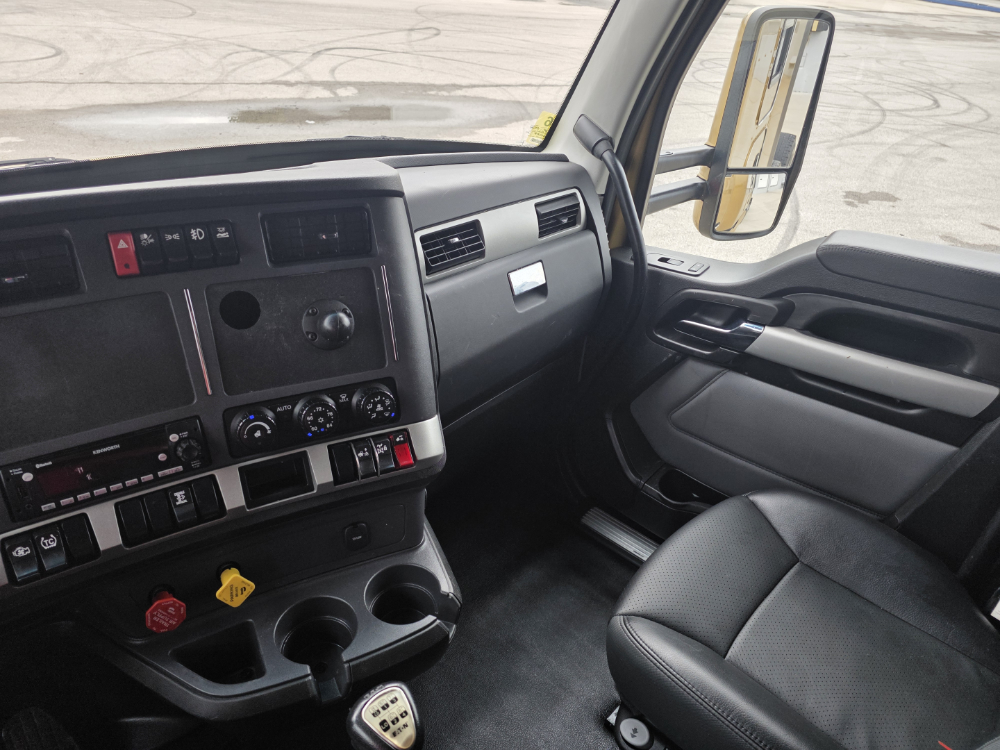 Kenworth T680 interior cab dash and steering wheel area with gear shifter and control panels visible.