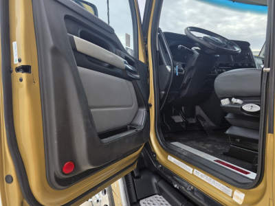 Kenworth T680 cab interior door and driver seat area visible with open door showing steering wheel and dashboard.