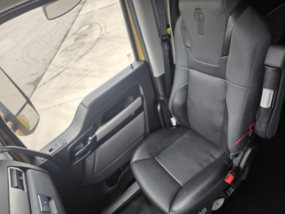 Cab interior of 2023 Kenworth T680 showing driver seat and door panel.