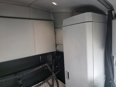 Interior view of Kenworth T680 cab with sleeper area and cabinet; no legible labels or fluid markings visible.