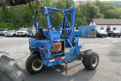Teledyne D5000 lift truck in blue with proof of model number 501 visible, rear view showing tires and operator cage in an outdoor lot.