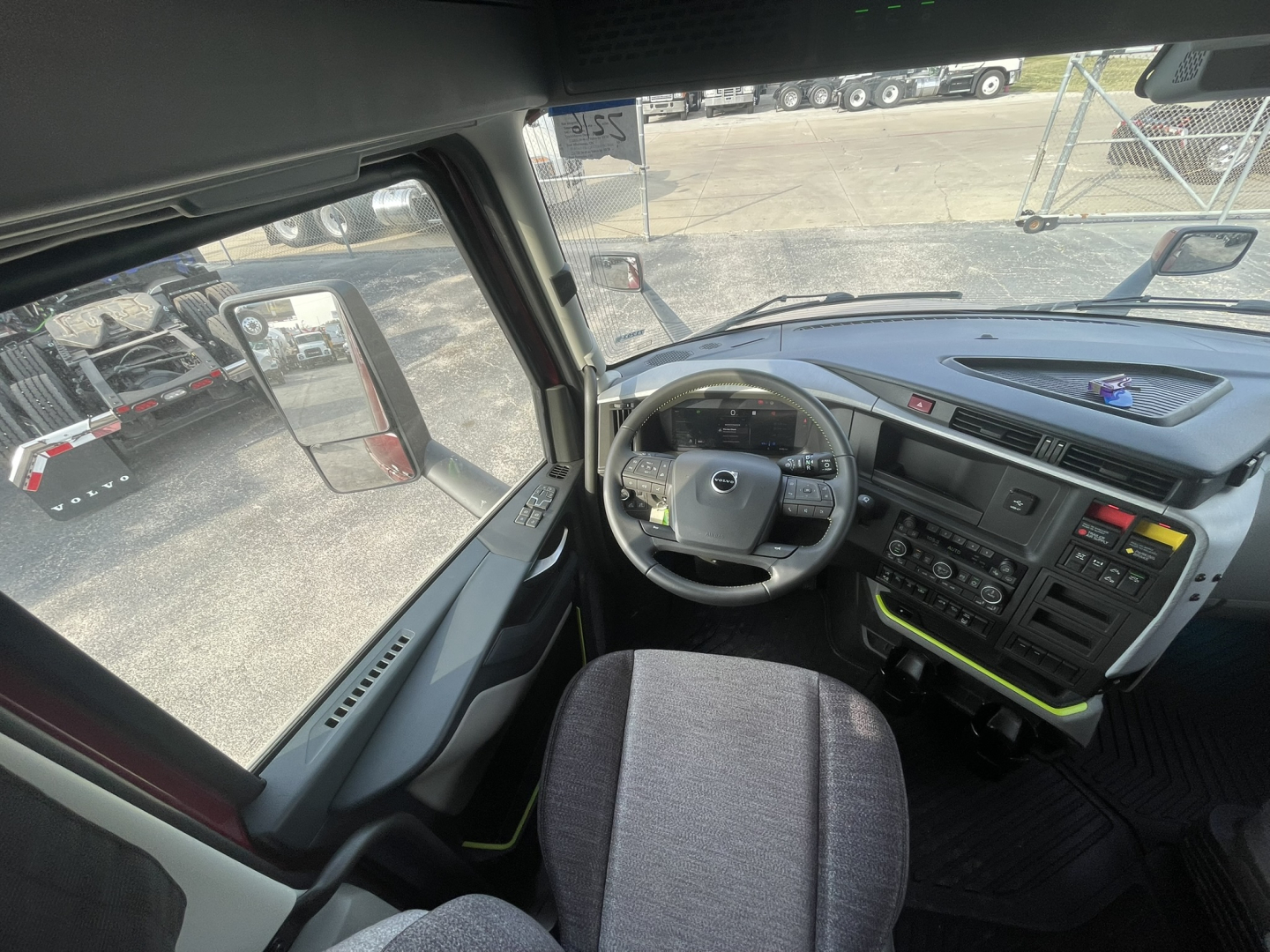Volvo VNL64T860 truck cab interior showing steering wheel/dash with multiple controls and driver seat.